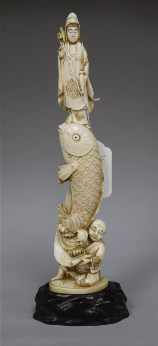 A Japanese ivory okimono of Kwannon standing upon a giant carp, early 20th century, H.24.3cms